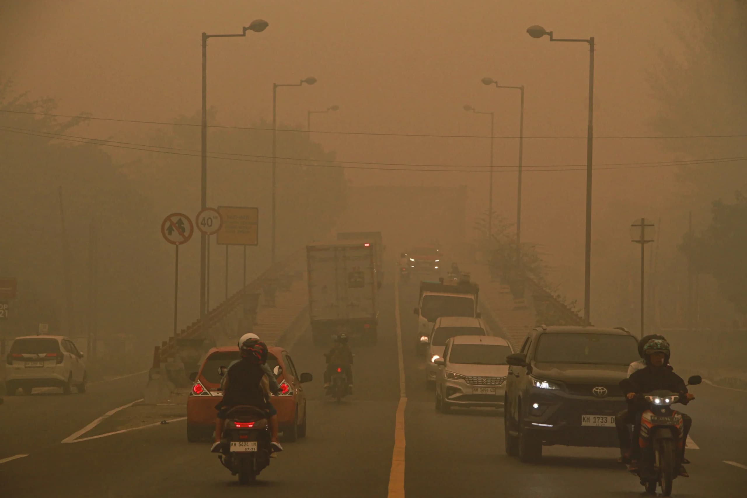 Pengendara motor melintas di Jembatan Kahayan yang diselimuti asap di Palangka Raya, Kalimantan Tengah Pengendara motor melintas di Jembatan Kahayan yang diselimuti asap di Palangka Raya, Kalimantan Tengah