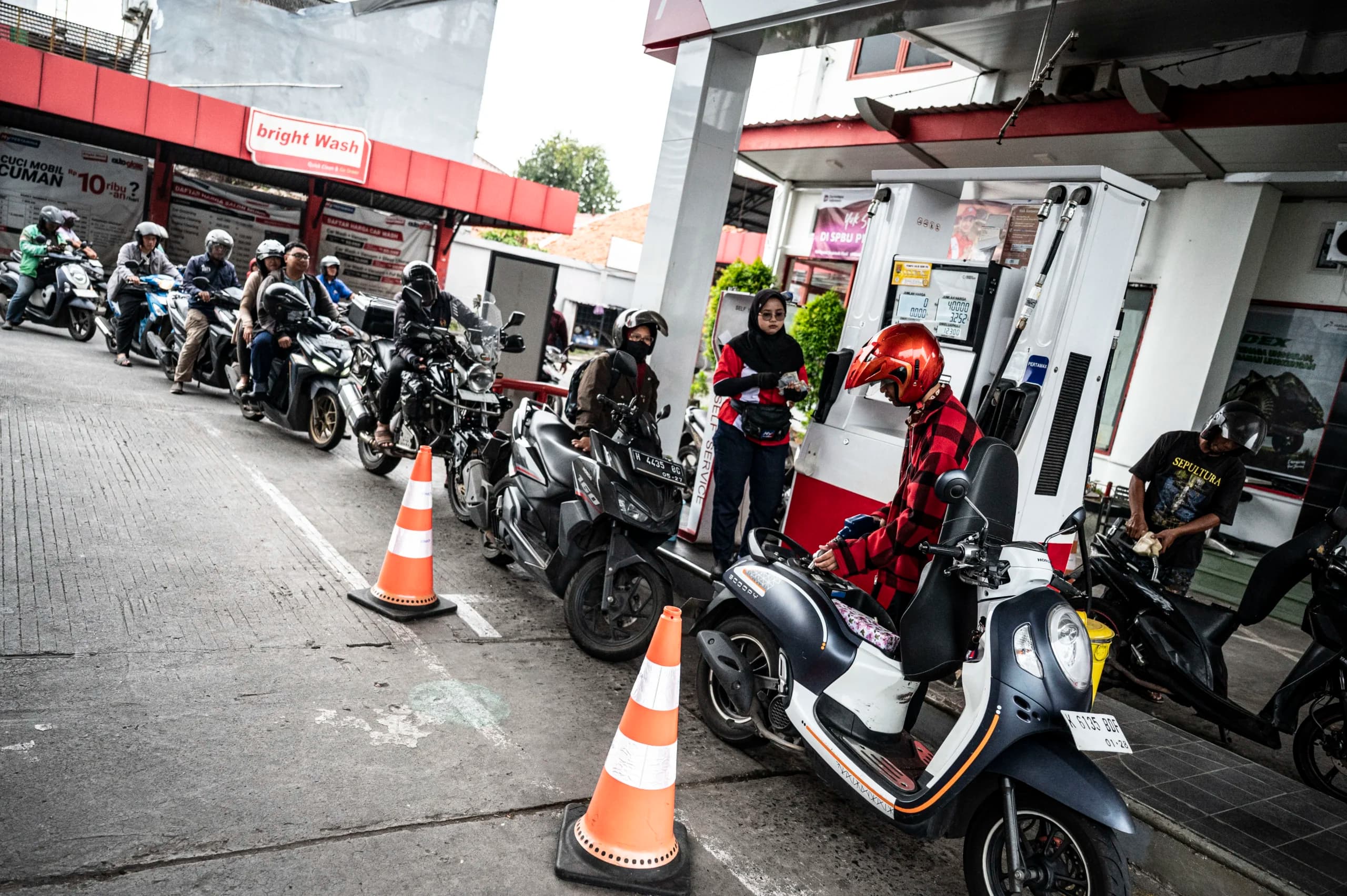 Pengendara sepeda motor mengisi bahan bakar minyak (BBM) Pengendara sepeda motor mengisi bahan bakar minyak (BBM)